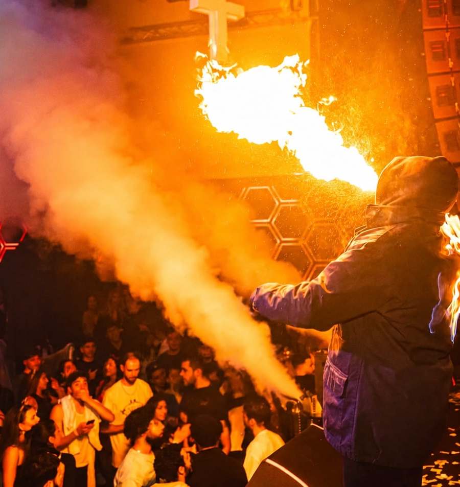 Fire breather on stage blowing a plume of flames over the crowd at an EPICO party in Brussels