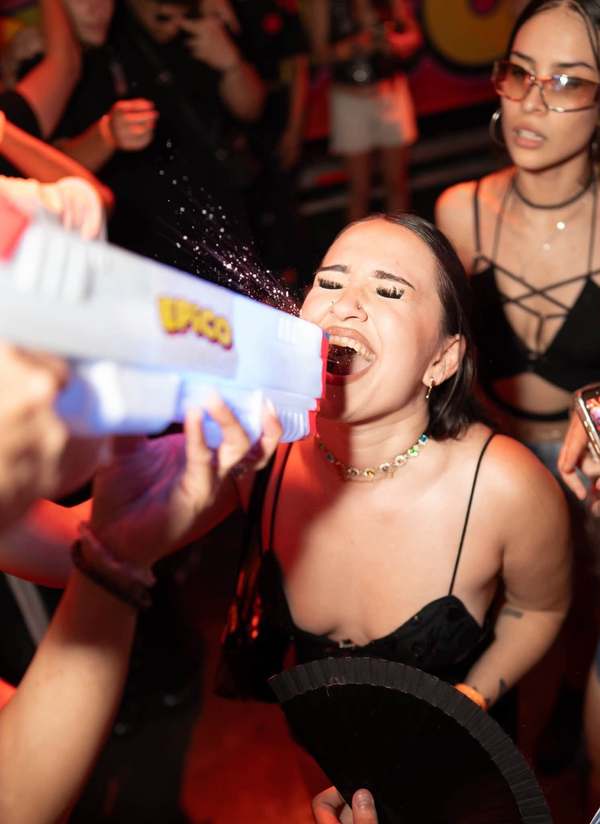 Partygoer bursting into laughter as she gets a shot from an EPICO-branded water gun